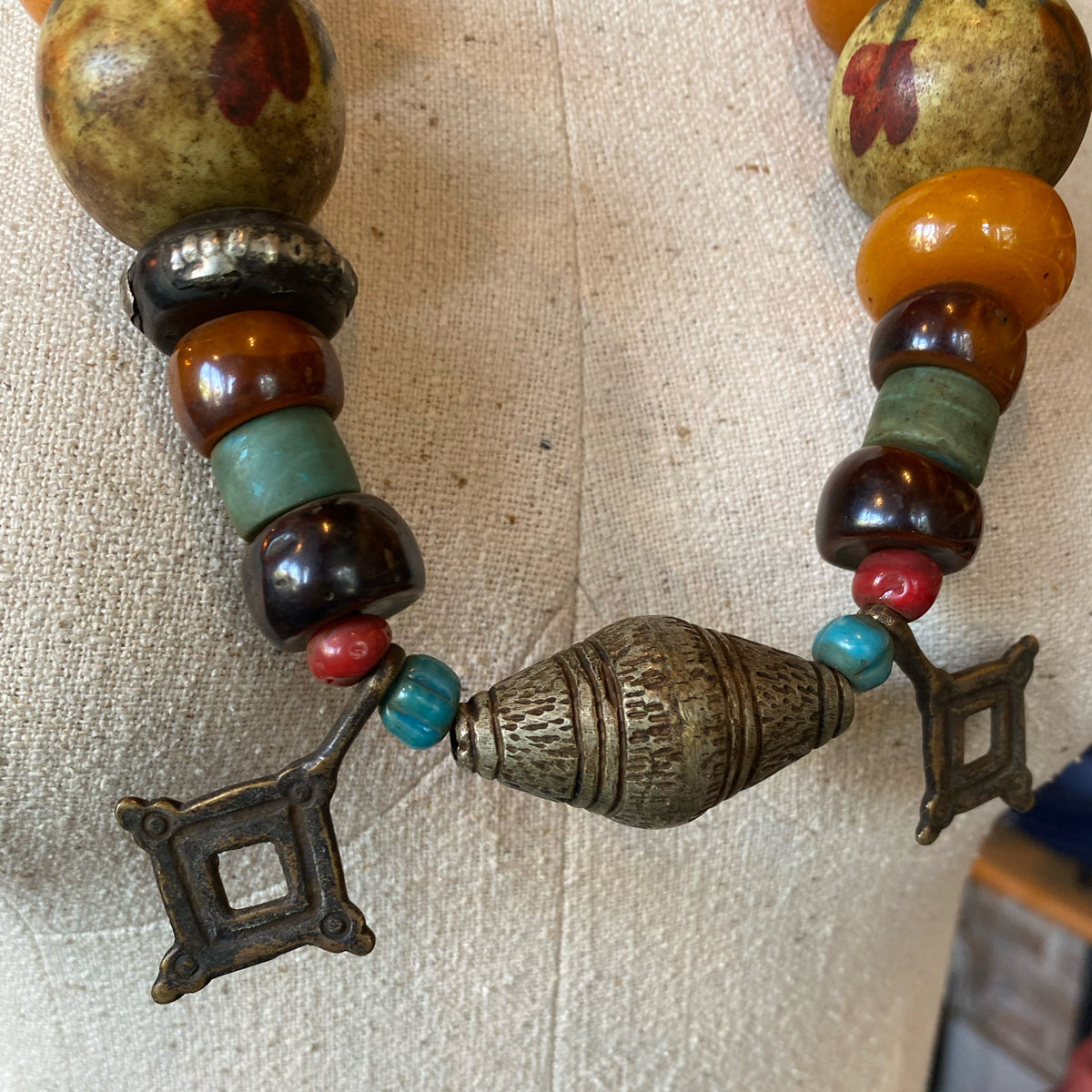 Close-up of a detailed vintage-style necklace with colorful beads and metal geometric accents from the Itahari collection.