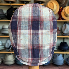 Americana Vintage Flat Cap featuring a classic plaid pattern in muted tones, displayed against a backdrop of various hats, highlighting its vintage charm and style.