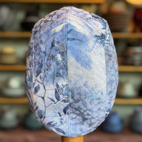 Cloud Leopard 2-Panel Ivy Cap featuring a subtle animal and floral print in soft blue and gray hues, designed as a stylish flat cap accessory.
