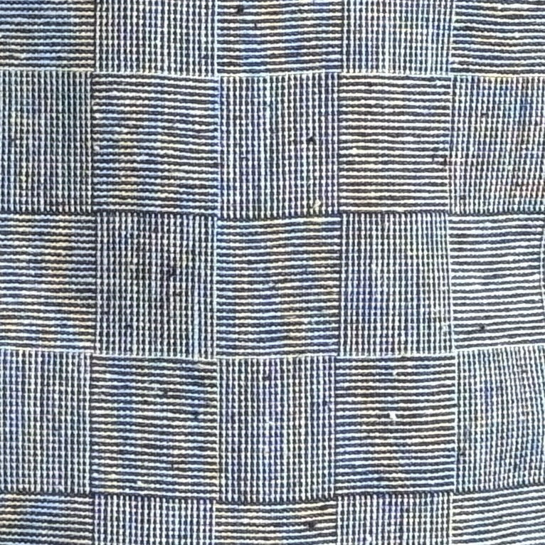 Close-up detail of textured fabric in a subtle checkered pattern on a Monochrome Vintage Flat Cap, showcasing fine stitching and a classic newsboy style design.