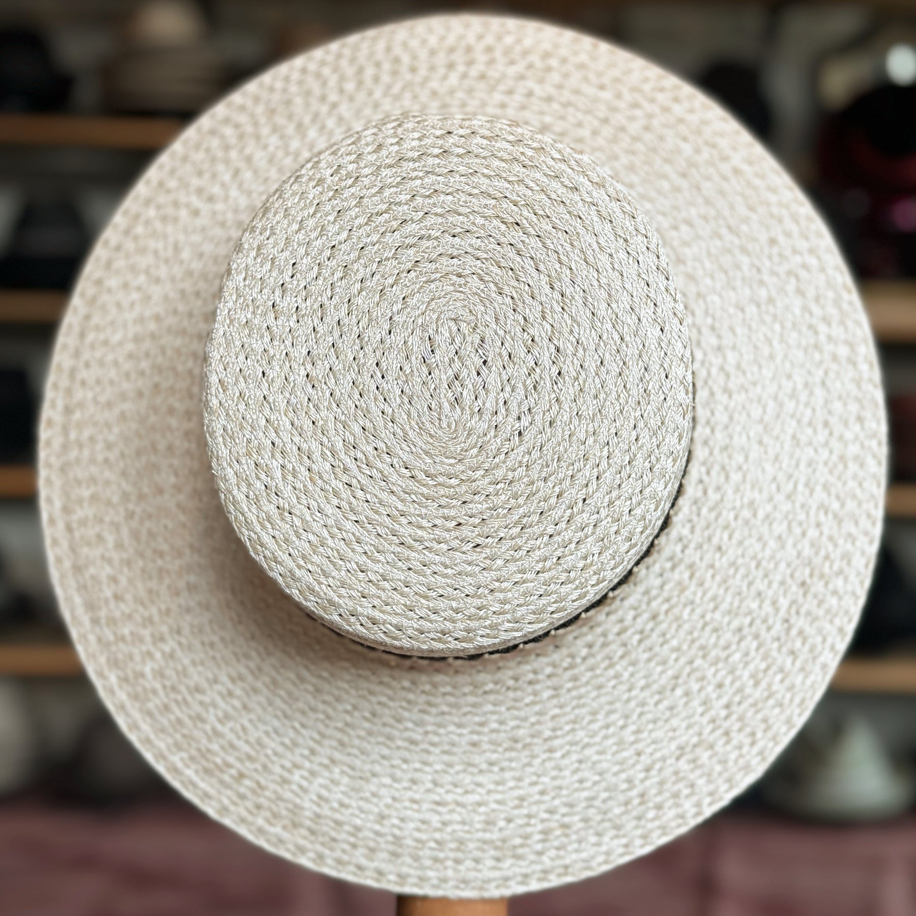 Noreen natural woven wide-brim hat featuring a textured spiral pattern, perfect for stylish sun protection and a classic accessory look.