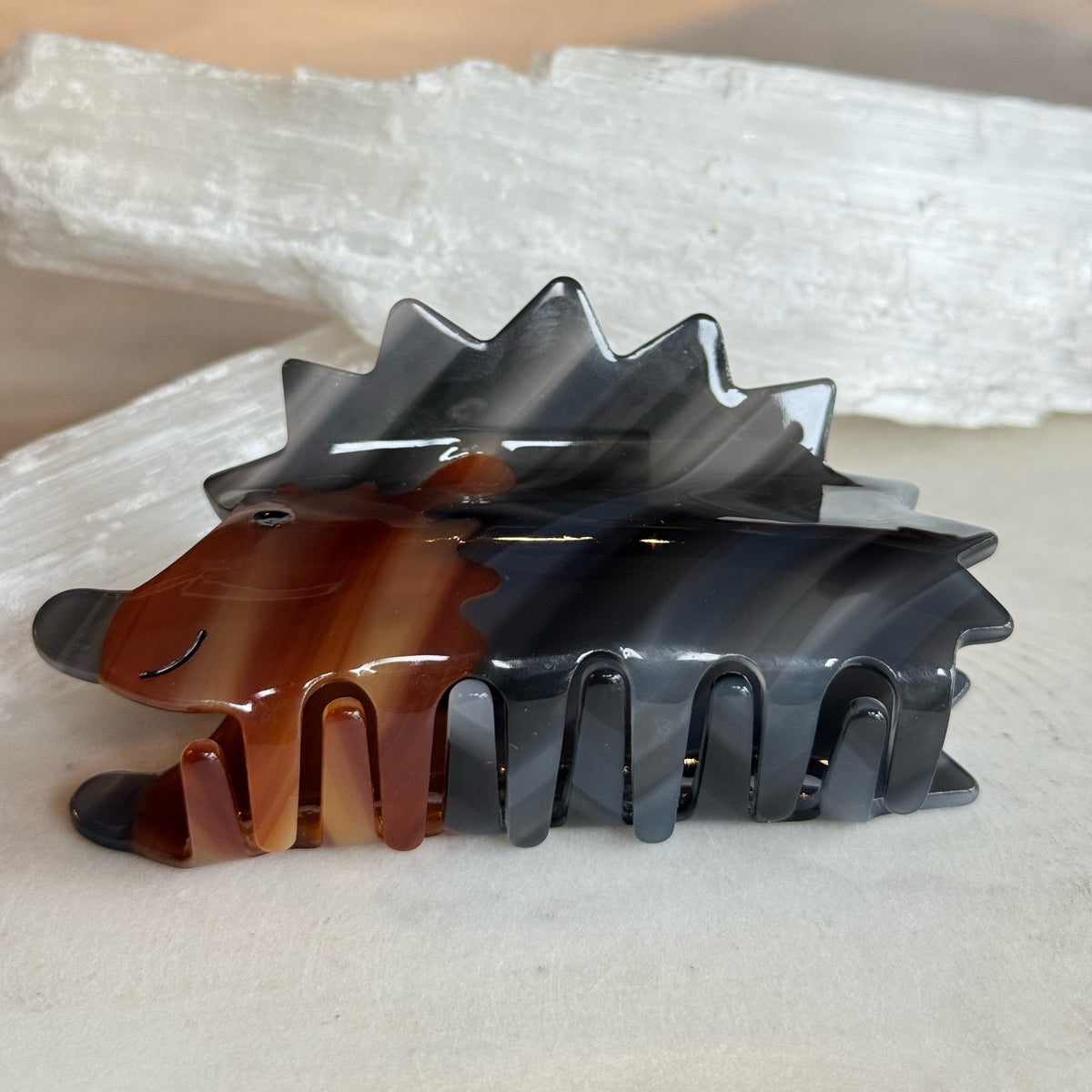 Hedge Hog Hair Clip made of glossy tortoiseshell-inspired plastic, designed with a smiling hedgehog shape and sturdy wide teeth for secure hair hold.
