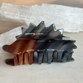 Hedge Hog Hair Clip made of glossy tortoiseshell-inspired plastic, designed with a smiling hedgehog shape and sturdy wide teeth for secure hair hold.