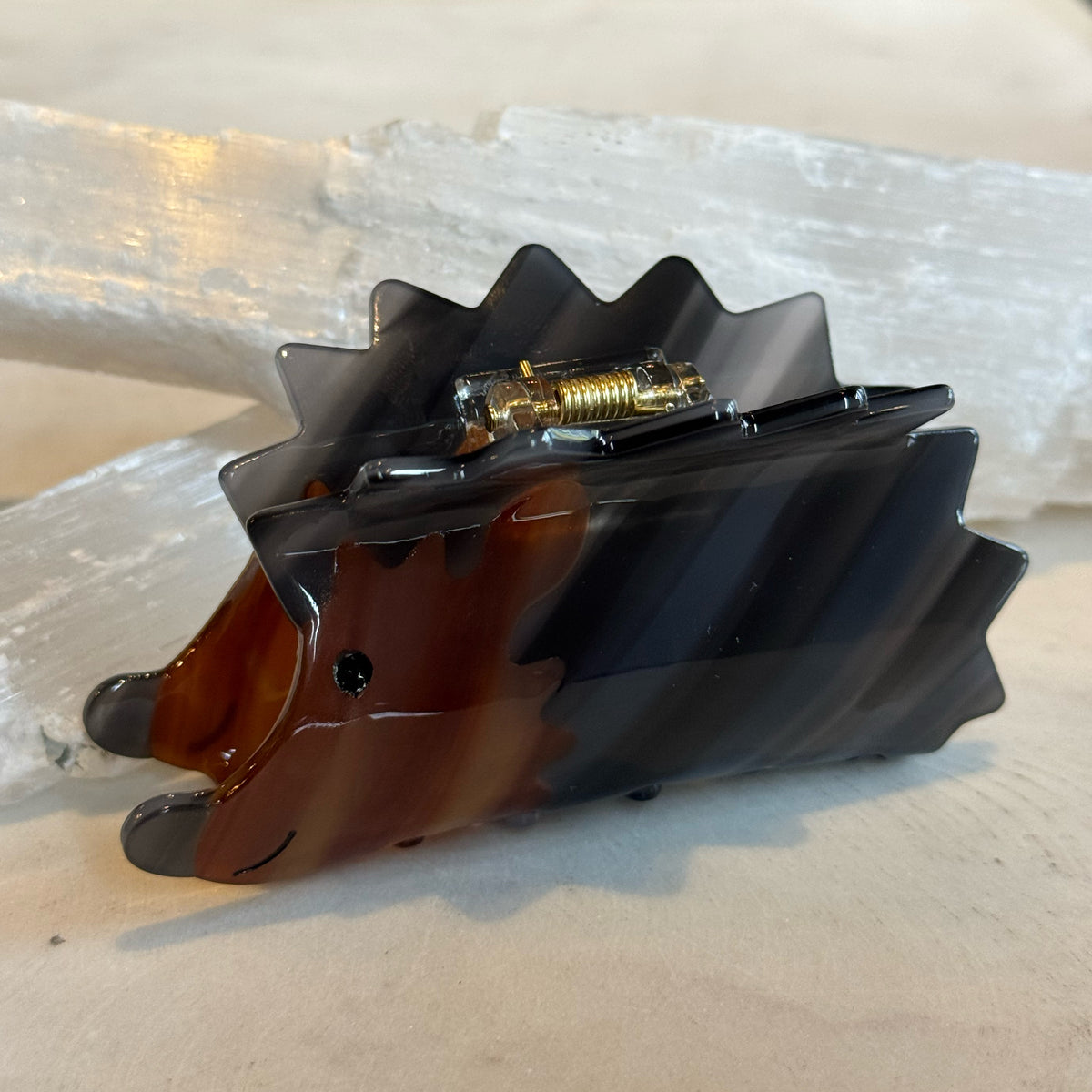 Hedge Hog Hair Clip shaped like a small hedgehog in glossy brown and black tones with a sleek plastic finish and metal clasp on the back, ideal as a cute hair accessory.