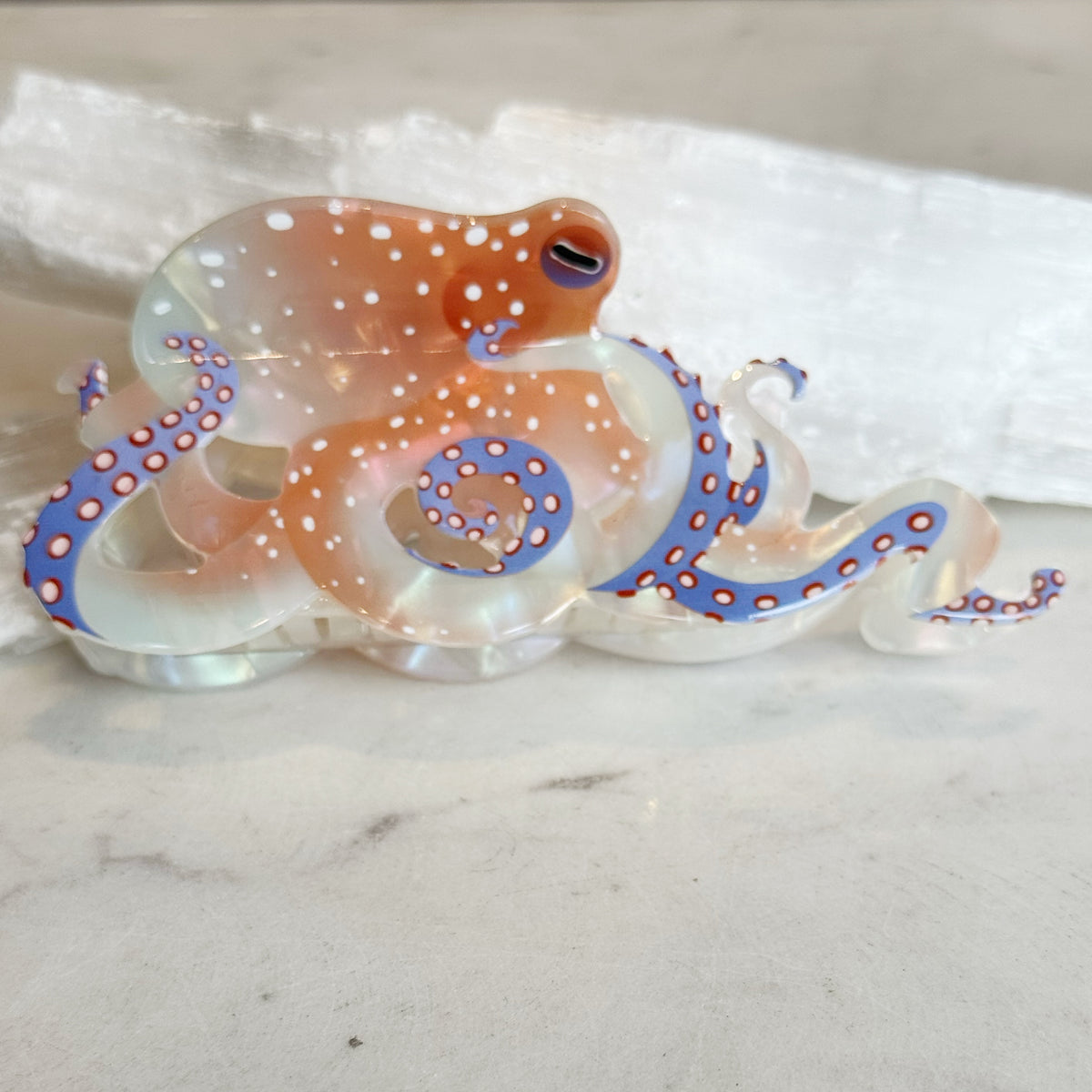 Detailed Octopus Hair Clip with translucent body, orange and blue tentacles, and white spots, designed as a stylish aquatic-inspired hair accessory.