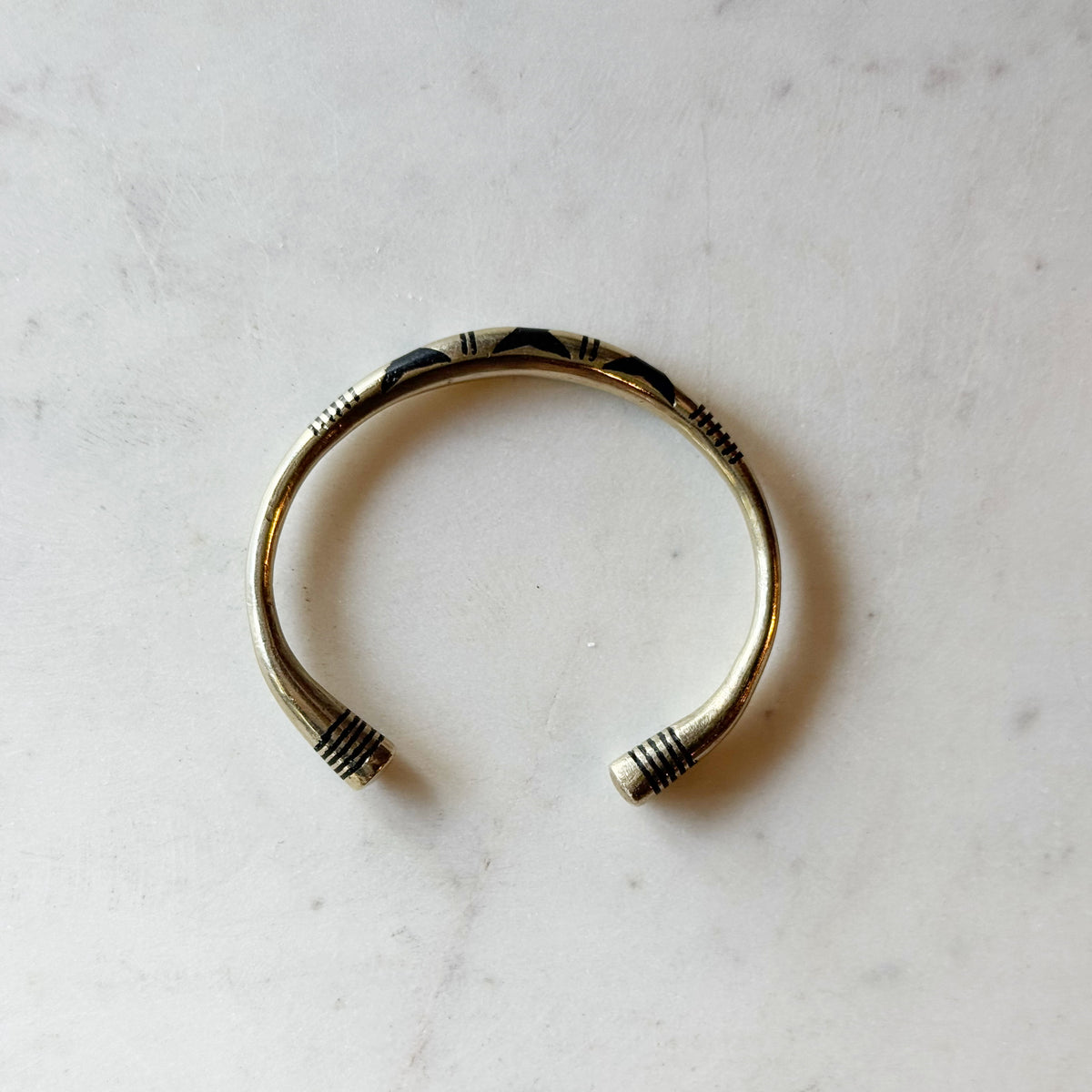 Tuareg Coin Silver Bracelet J features a handcrafted silver cuff design with intricate tribal patterns and open ends, showcasing authentic Tuareg craftsmanship.